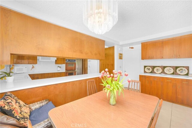 18132 James Rd, Villa Park, CA 92861 - dining room with a textured ceiling, a chandelier, and light tile patterned floors
