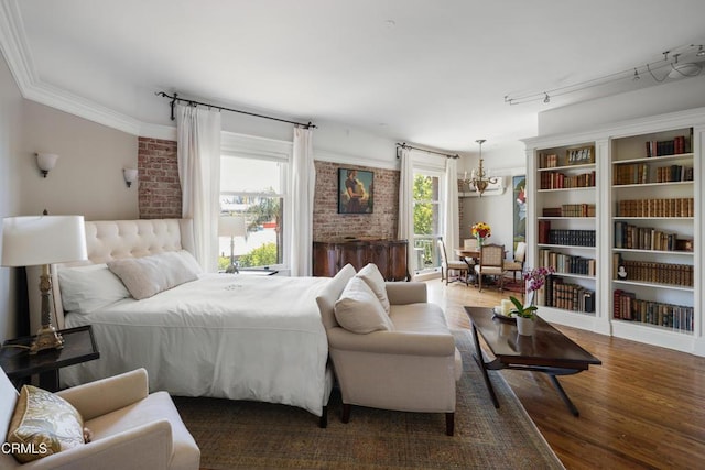 99 S Raymond Ave Unit 409, Pasadena, CA 91105 - bedroom with a chandelier, wood finished floors, crown molding, and brick wall