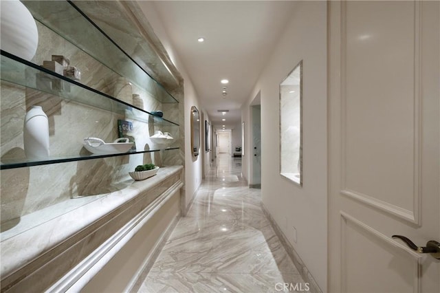 corridor featuring light marble finish flooring, recessed lighting, and baseboards