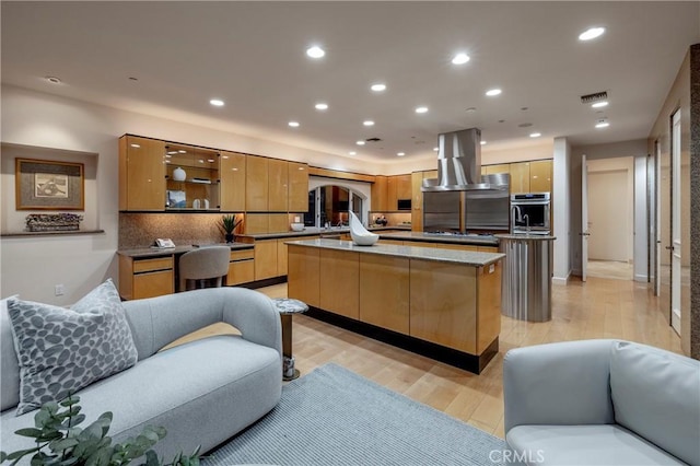 kitchen featuring island range hood, a kitchen island, modern cabinets, stainless steel oven, and recessed lighting
