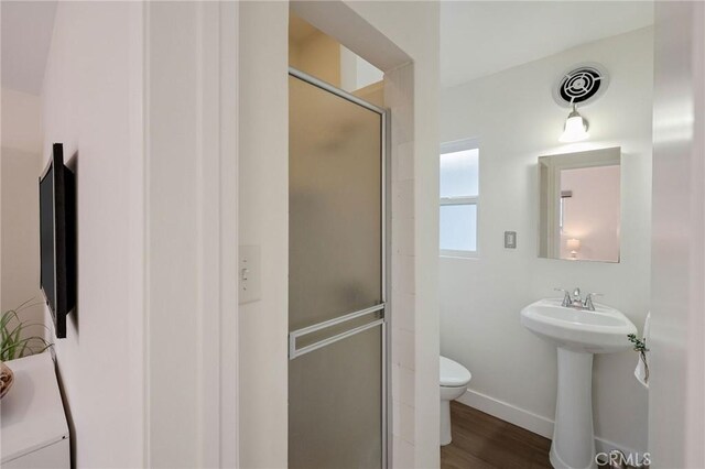 18017 Glenburn Ave, Torrance, CA 90504 - bathroom featuring a stall shower, toilet, baseboards, wood finished floors, and a sink