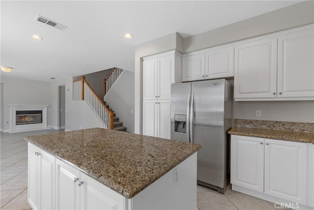 42631 Hussar Ct, Temecula, CA 92592 - kitchen with stainless steel fridge with ice dispenser, light tile patterned floors, a center island, white cabinetry, and recessed lighting