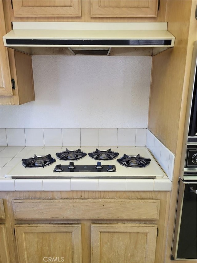40132 Zamura Ct, Murrieta, CA 92562 - kitchen with white gas cooktop, light brown cabinets, decorative backsplash, and under cabinet range hood