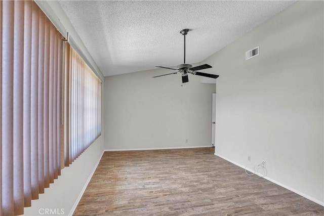 29331 Mawr Ct, Menifee, CA 92586 - unfurnished room featuring ceiling fan, vaulted ceiling, wood finished floors, a textured ceiling, and baseboards