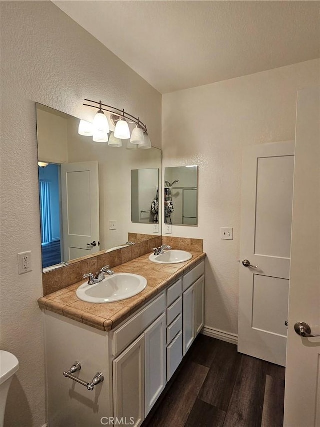 7331 Shelby Pl Unit 121, Rancho Cucamonga, CA 91739 - full bath featuring wood finished floors, double vanity, a textured wall, and toilet