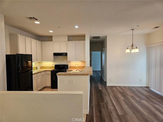 7331 Shelby Pl Unit 121, Rancho Cucamonga, CA 91739 - kitchen with black appliances, dark wood-style floors, baseboards, a chandelier, and tile countertops