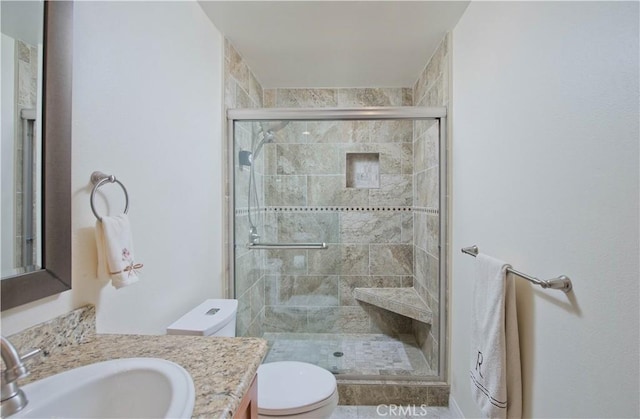 bathroom featuring a stall shower, vanity, and toilet