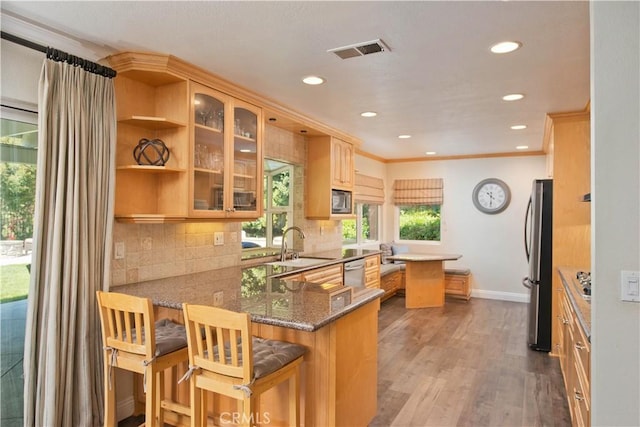 kitchen with appliances with stainless steel finishes, baseboards, recessed lighting, a sink, and glass insert cabinets
