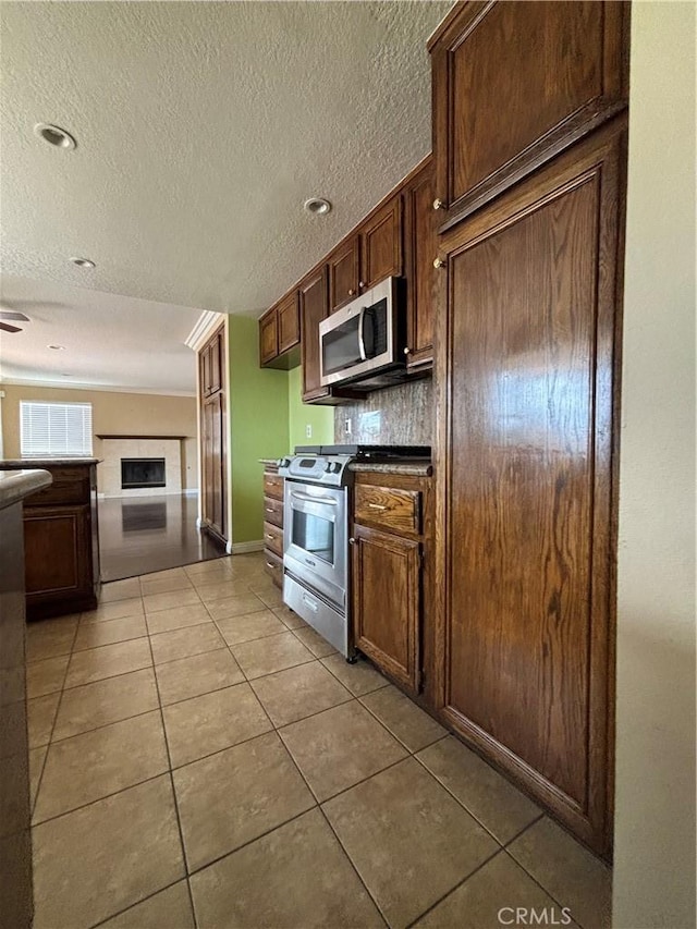 17092 Whispering Brook Way, Riverside, CA 92503 - kitchen with appliances with stainless steel finishes, light tile patterned floors, a textured ceiling, decorative backsplash, and open floor plan