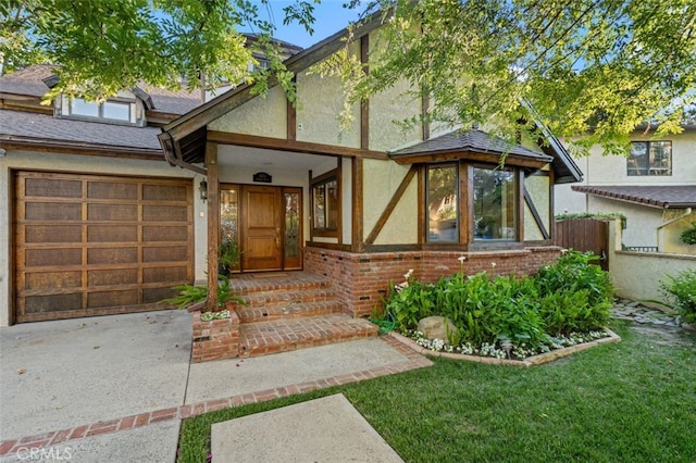 view of front of house featuring stucco siding, driveway, a garage, brick siding, and roof with shingles