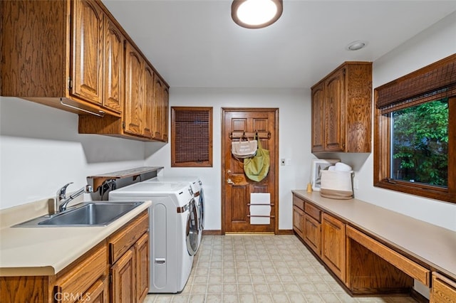 laundry room with light flooring, washing machine and clothes dryer, cabinet space, and baseboards