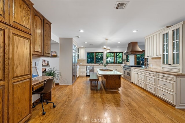 kitchen featuring custom exhaust hood, high end appliances, tasteful backsplash, light countertops, and recessed lighting