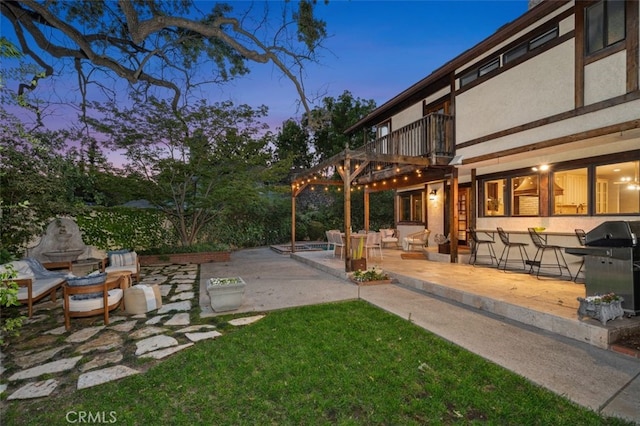 view of green lawn with a balcony and a patio
