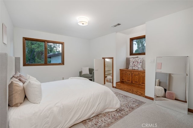 bedroom featuring multiple windows and light colored carpet