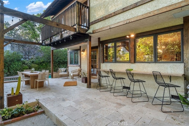 view of patio / terrace featuring a balcony and outdoor dining space
