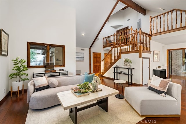 living room featuring hardwood / wood-style floors, high vaulted ceiling, stairs, beam ceiling, and baseboards
