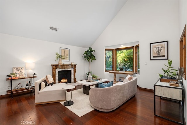 living room featuring a brick fireplace, dark wood finished floors, baseboards, and high vaulted ceiling