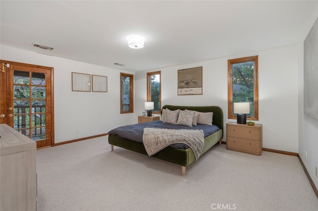 bedroom with light colored carpet, baseboards, and access to exterior