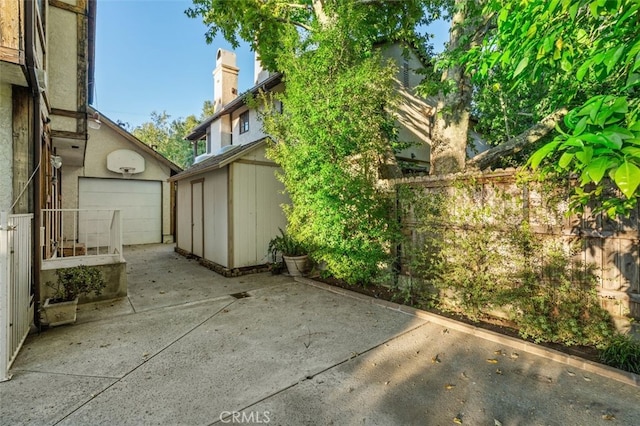 view of patio / terrace featuring a shed, an outbuilding, and fence
