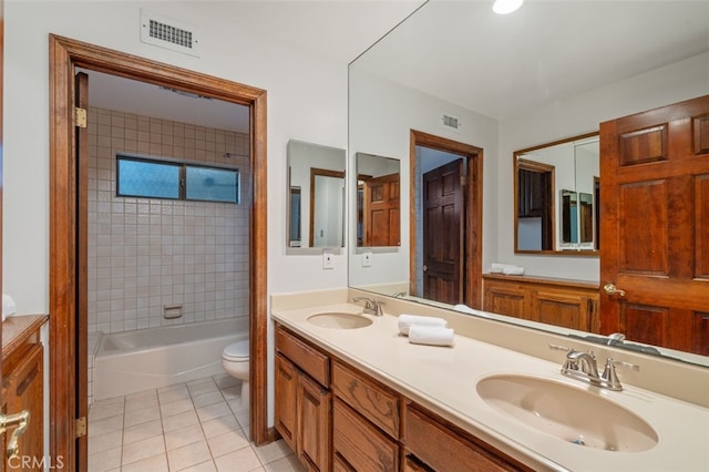 bathroom featuring tile patterned floors, toilet, double vanity, and shower / washtub combination