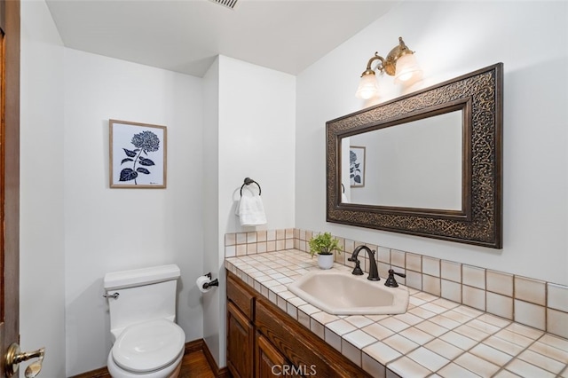 half bathroom with vanity and toilet