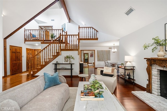 living area with high vaulted ceiling, wood finished floors, stairs, a fireplace, and baseboards