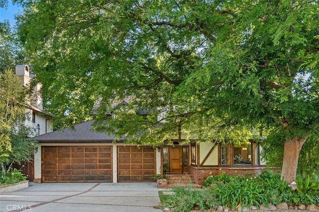 view of front facade with driveway, brick siding, and a garage