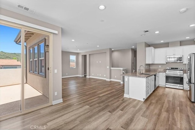 7501 Eagle Dr Unit 101, Santee, CA 92071 - kitchen featuring stainless steel appliances, a sink, a peninsula, wood finished floors, and white cabinetry