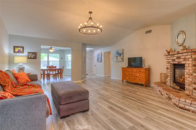 324 Crater Lake Dr, Chico, CA 95973 - living room featuring a chandelier, vaulted ceiling, light wood-style floors, a fireplace, and a ceiling fan