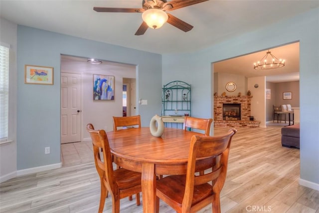 324 Crater Lake Dr, Chico, CA 95973 - dining space with a fireplace, light wood-style flooring, baseboards, a ceiling fan, and a chandelier
