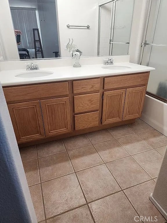 full bathroom featuring tile patterned floors, double vanity, and shower / bath combination with glass door
