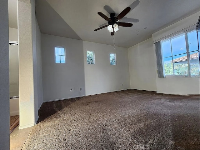 carpeted spare room with healthy amount of natural light, ceiling fan, baseboards, and lofted ceiling