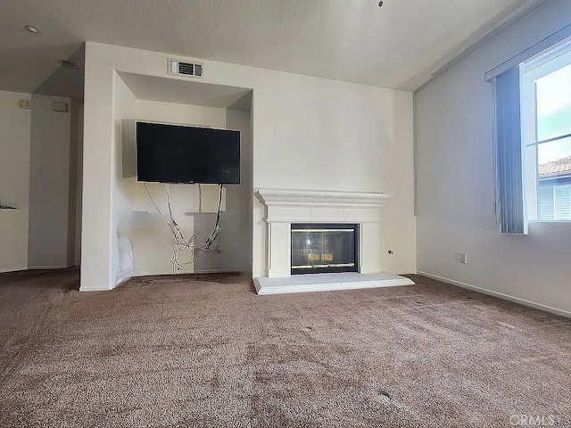 unfurnished living room featuring carpet flooring, baseboards, and a glass covered fireplace