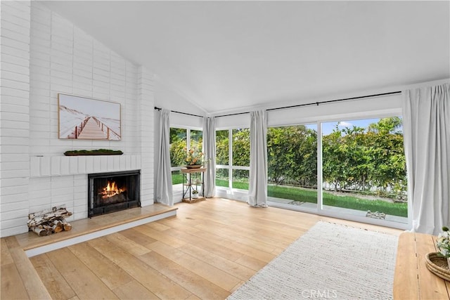 249 Calle Empalme, San Clemente, CA 92672 - unfurnished living room with lofted ceiling, healthy amount of natural light, a fireplace, and wood finished floors