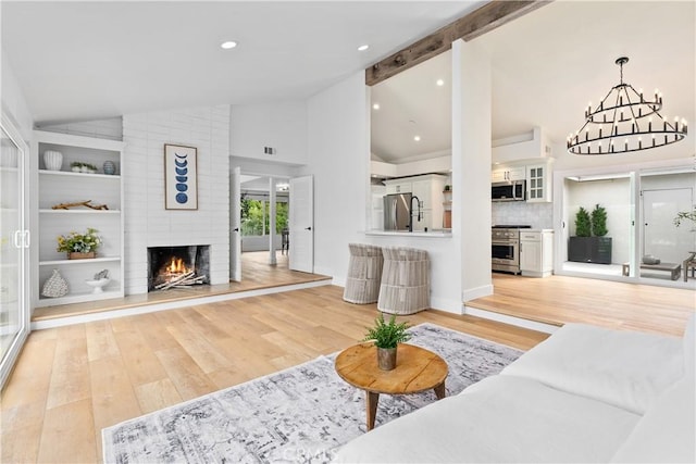249 Calle Empalme, San Clemente, CA 92672 - living room featuring light wood-style floors, a brick fireplace, a chandelier, high vaulted ceiling, and recessed lighting