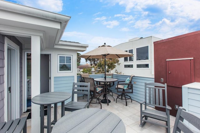 wooden terrace featuring outdoor dining area and a patio