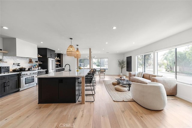 5681 E Colorado St, Long Beach, CA 90814 - kitchen featuring high end appliances, open shelves, light countertops, recessed lighting, and light wood-style floors
