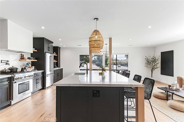 5681 E Colorado St, Long Beach, CA 90814 - kitchen featuring high end appliances, a sink, a kitchen breakfast bar, light wood-type flooring, and recessed lighting