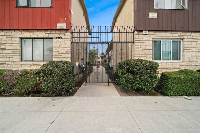 617 Cedar Ave Unit 11, Long Beach, CA 90802 - property entrance featuring a gate, stone siding, and board and batten siding