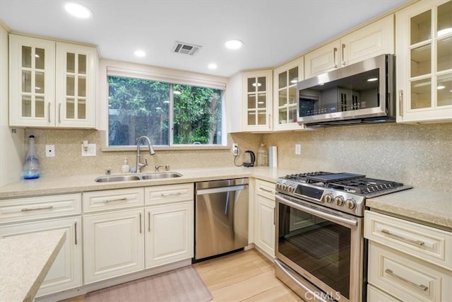 9315 Woodman Ave Unit 8, Arleta, CA 91331 - kitchen featuring stainless steel appliances, a sink, light countertops, decorative backsplash, and light wood-style flooring