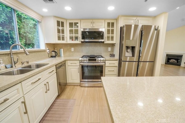 9315 Woodman Ave Unit 8, Arleta, CA 91331 - kitchen with appliances with stainless steel finishes, a sink, light wood-style flooring, tasteful backsplash, and recessed lighting