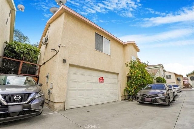 9315 Woodman Ave Unit 8, Arleta, CA 91331 - view of side of property with stucco siding, concrete driveway, and a garage