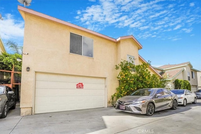 9315 Woodman Ave Unit 8, Arleta, CA 91331 - townhome / multi-family property with an attached garage, stucco siding, and driveway