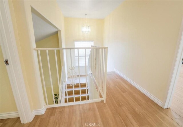 9315 Woodman Ave Unit 8, Arleta, CA 91331 - corridor with a chandelier, wood finished floors, and baseboards