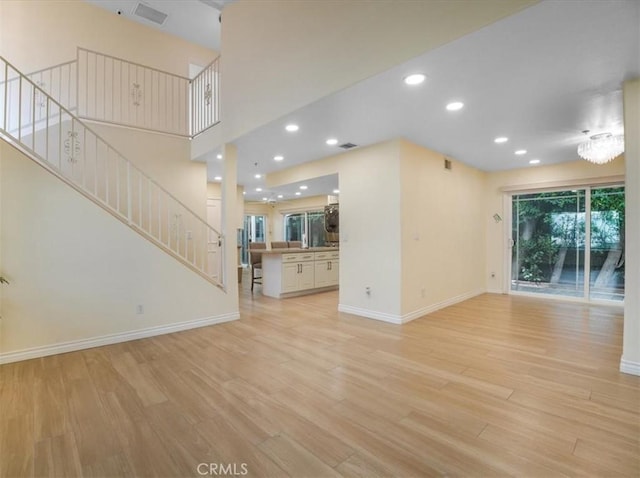 9315 Woodman Ave Unit 8, Arleta, CA 91331 - unfurnished living room with stairs, light wood-style floors, baseboards, and recessed lighting