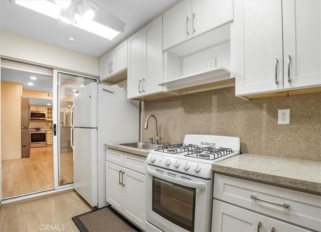 9315 Woodman Ave Unit 8, Arleta, CA 91331 - kitchen featuring stainless steel appliances, a sink, range hood, open shelves, and light wood-style floors
