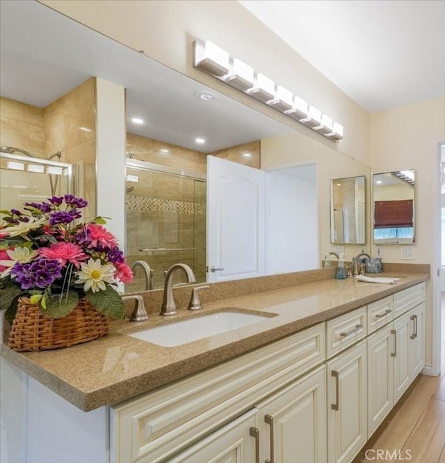 9315 Woodman Ave Unit 8, Arleta, CA 91331 - bathroom featuring double vanity, a stall shower, and wood finished floors