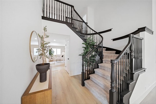 30901 Wellington Cir, Temecula, CA 92591 - stairway featuring a high ceiling, wood finished floors, and baseboards