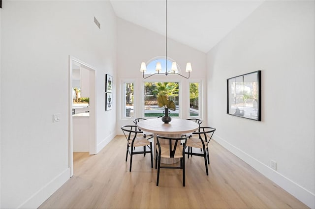 30901 Wellington Cir, Temecula, CA 92591 - dining room featuring light wood-style flooring, high vaulted ceiling, baseboards, and a chandelier