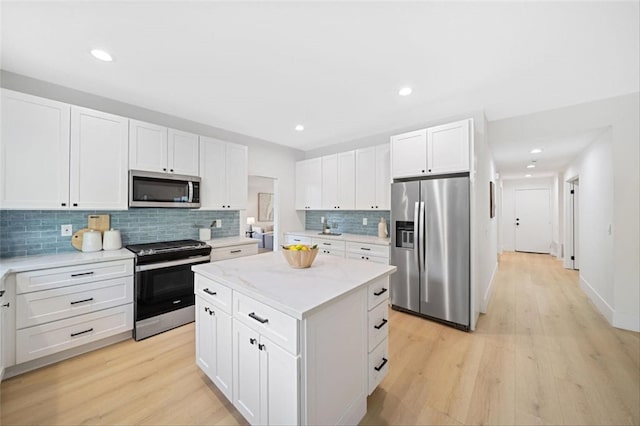 30901 Wellington Cir, Temecula, CA 92591 - kitchen featuring appliances with stainless steel finishes, a center island, tasteful backsplash, light wood-style floors, and recessed lighting